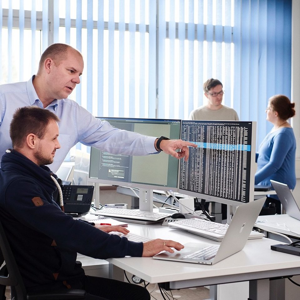 Zwei Mitarbeiter bei der Arbeit sprechen über eine Darstellung am Bildschirm