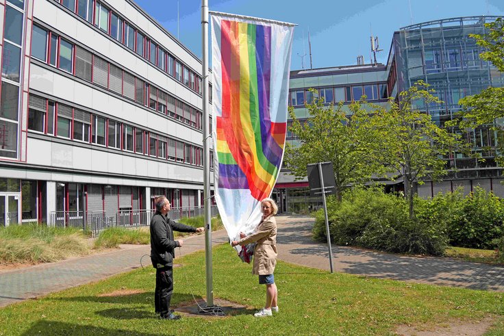 Inga Wachtmann hisst eine Regenbogenflagge vor dem Bürogebäude von Dataport