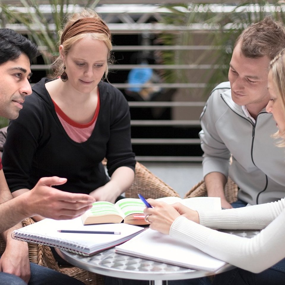 Bürgerbeteiligung: Vier Menschen diskutieren an einem Tisch