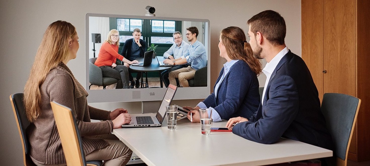 Drei Mitarbeiten nehmen an einer Videokonferenz teil