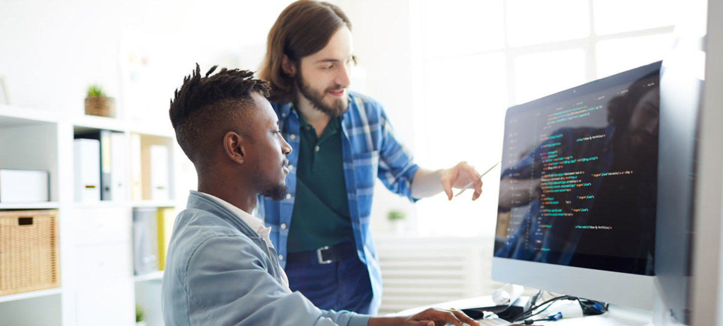 Zwei Programmierer blicken im Büro auf einen Bildschirm
