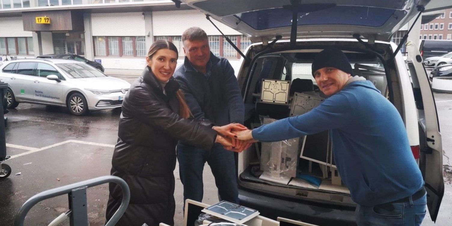 Drei Personen räumen Hardware in einen Transporter