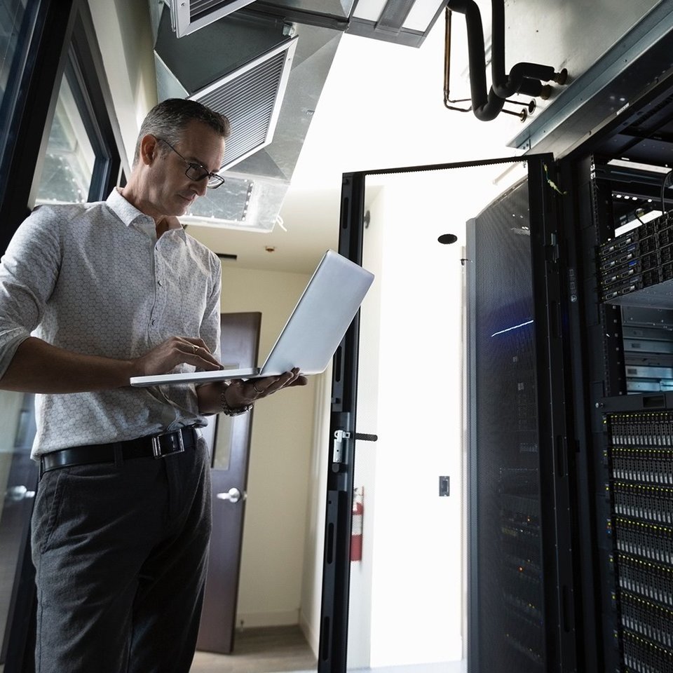 IT-Techniker mit Laptop im Serverraum