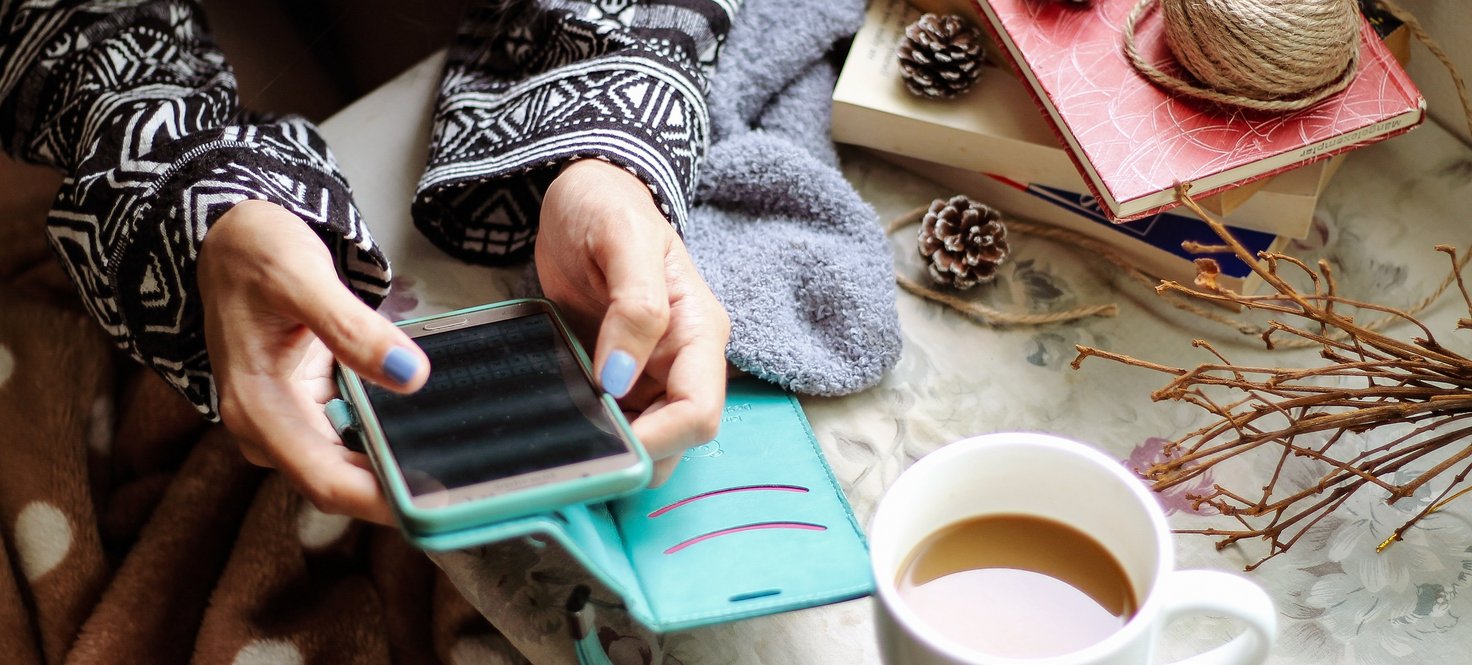 Frau mit einemSmartphone und einem Kaffee