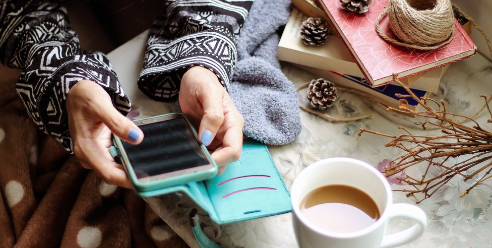 Frau mit einemSmartphone und einem Kaffee