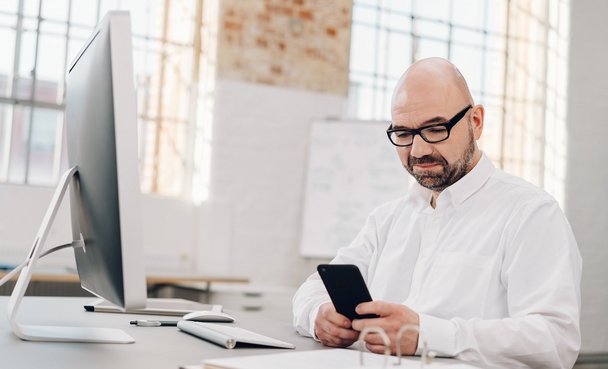 Mann am Handy: Digitale Chats für Teams erhöhen die Effizienz im Arbeitsalltag. Mit dMessenger bieten wie Ihnen dafür eine sichere und datenschutzkonforme Lösung für den öffentlichen Sektor. Mit zusätzlichen Funktionen für Notfälle.