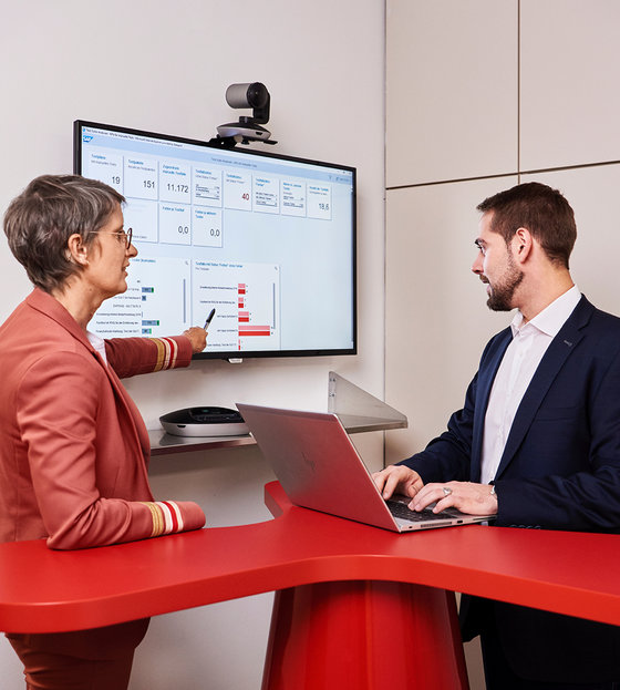 Zwei Mitarbeiter*innen arbeiten an einem Screen