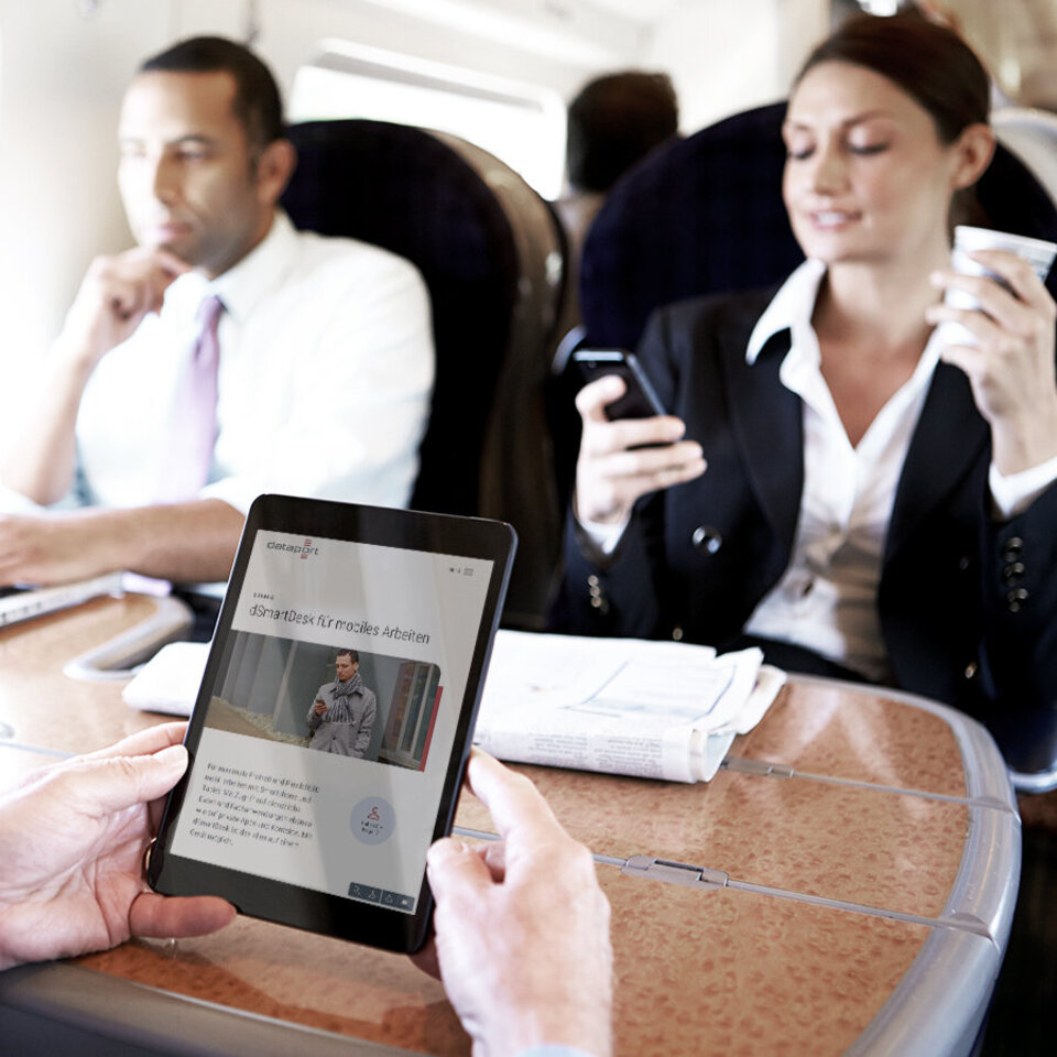 Geschäftsleute sitzen im Zug und nutzen mobile Endgeräte