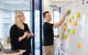 Zwei Personen vor einem Whiteboard mit Post-Its darauf