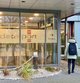 Eine Mitarbeiterin läuft mit einem Dataport Onboarding-Rucksack auf dem Rücken auf den Haupteingang des Dataport Standorts in Altenholz zu.