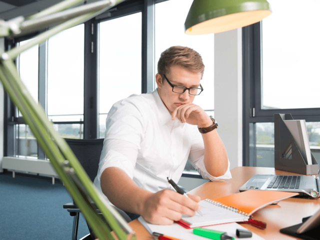 Abschlussarbeit Student lernt am Schreibtisch