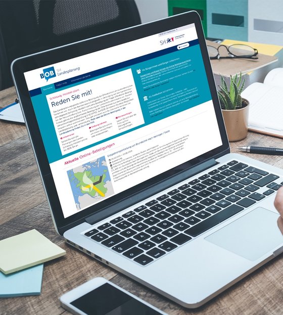 BOB-SH Mensch am aufgeschlagenem Laptop mit BOB-SH-Webseite