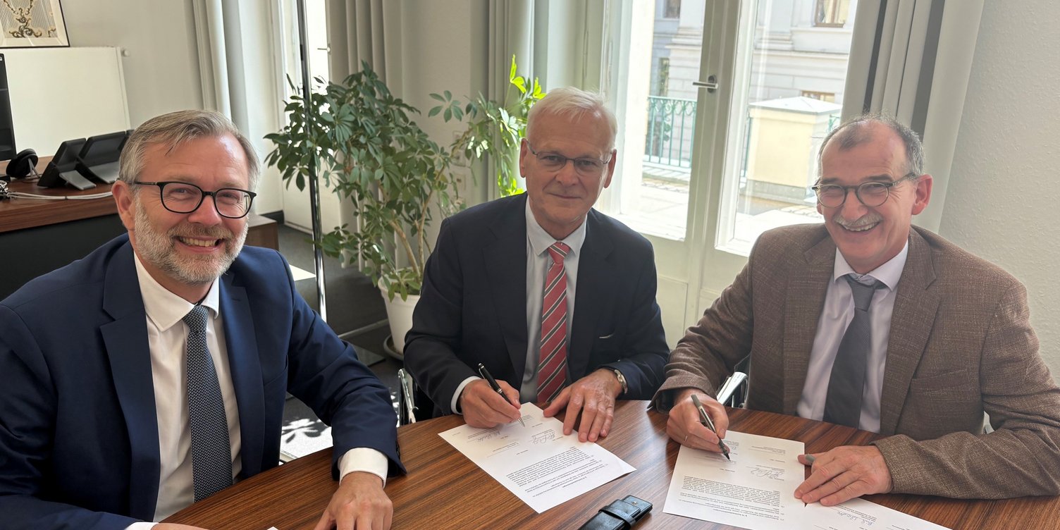 Dr. Heiko Geue, Hubert Ludwig und Dr. Johann Bizer bei der Unterzeichnung der Vereinbarung.
