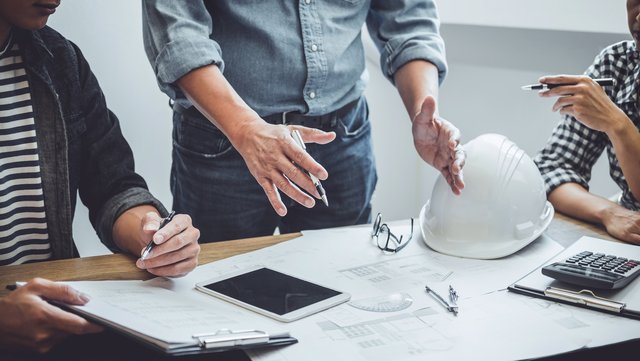 Ingenieure und Architekten besprechen einen Bauleitplan