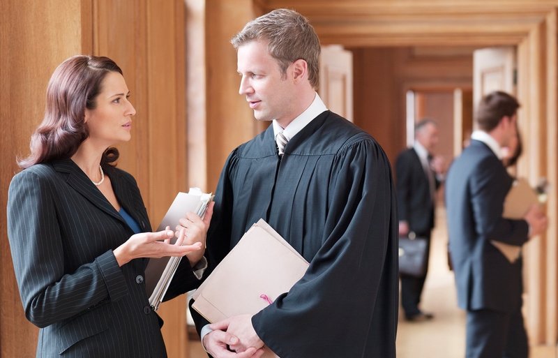 Richter und Anwältin sprechen im Korridor eines Justizgebäudes
