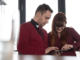 Studenten unterhalten sind und zeigen auf Smartphone