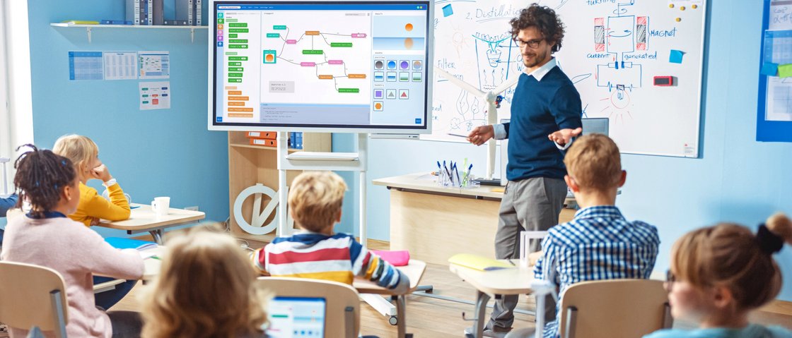 Lehrer spricht vor Schülern bei Benutzung eines Smartboards