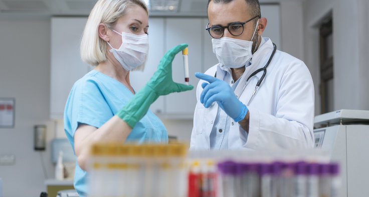 Zwei Medizinisch-Technische Assistent*innen (MTAs) untersuchen eine Blutprobe
