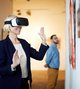Eine Frau schaut sich mit einer VR-Brille ein Gemälde in einem Museum an