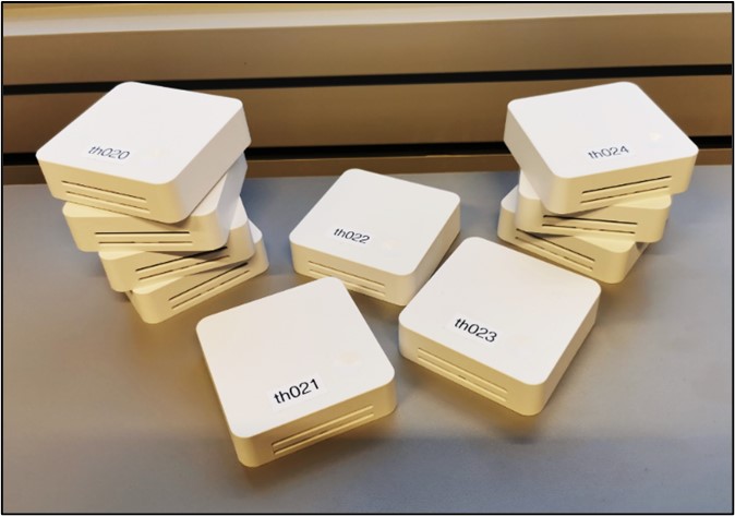 Mehrere LoRaWAN-Sensoren liegen gestapelt auf einem Tisch. 